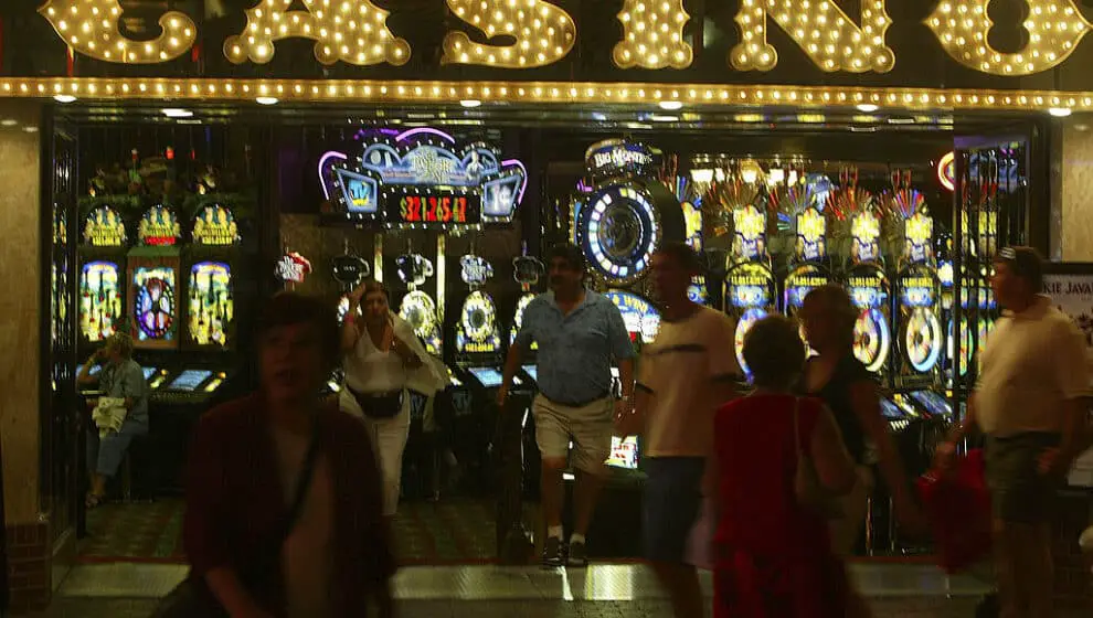 Pedestrians walk past a Casino at night on Las Vegas Boulevard